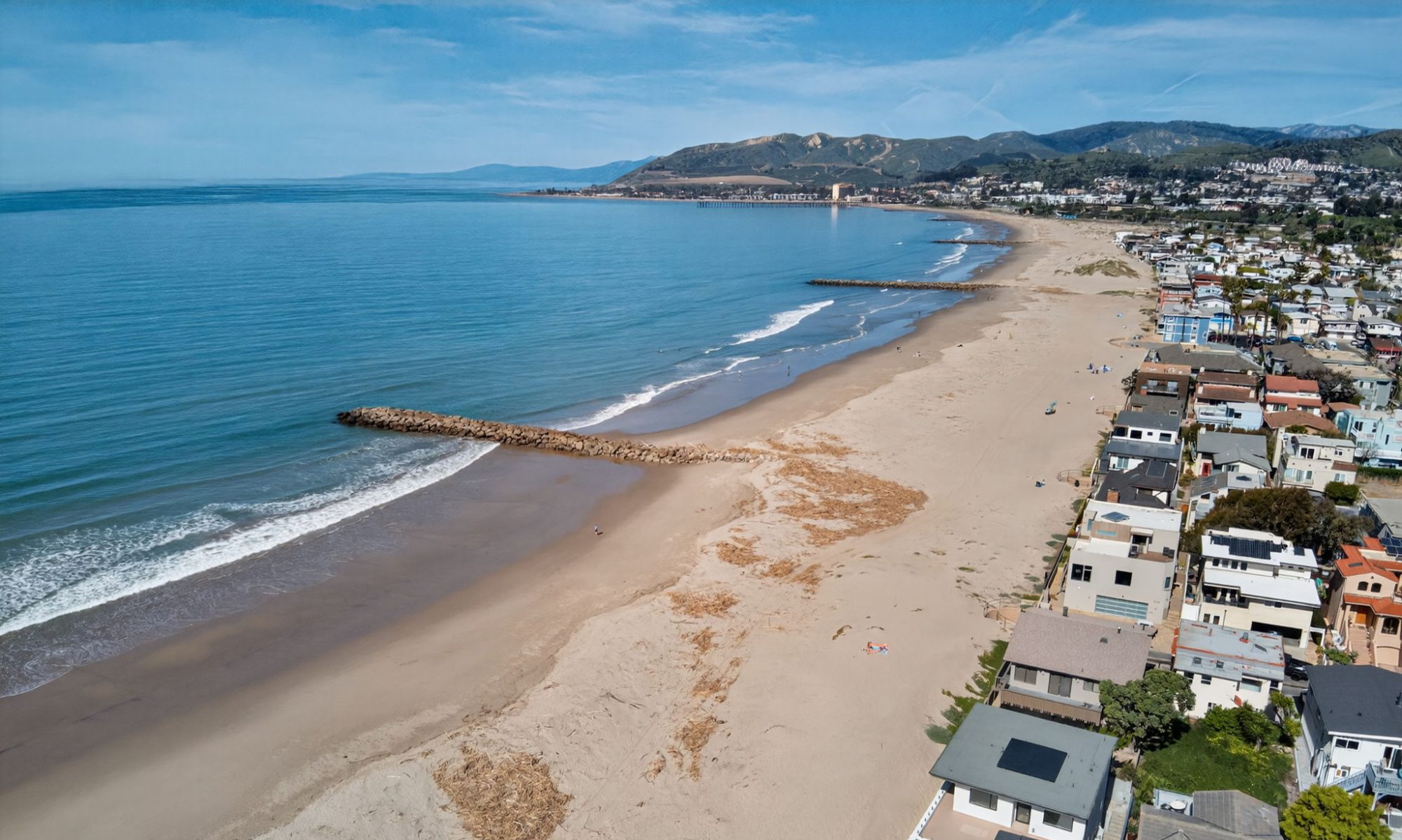 Drone aerial view of Ventura California coastline with beachfront homes along Kingston Lane and sandy beach shoreline